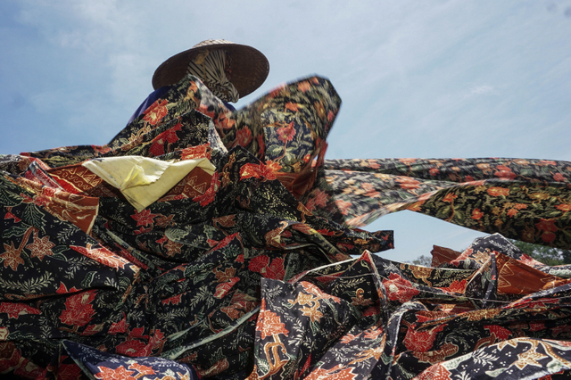 Pekerja menjemur kain batik sepanjang sekitar 125-250 meter di Medono, Pekalongan, Jawa Tengah (22/9/2021). Foto: ANTARA FOTO/Harviyan Perdana Putra