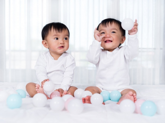 Ilustrasi bayi kembar laki-laki bermain bola bersama. Foto: Freepik