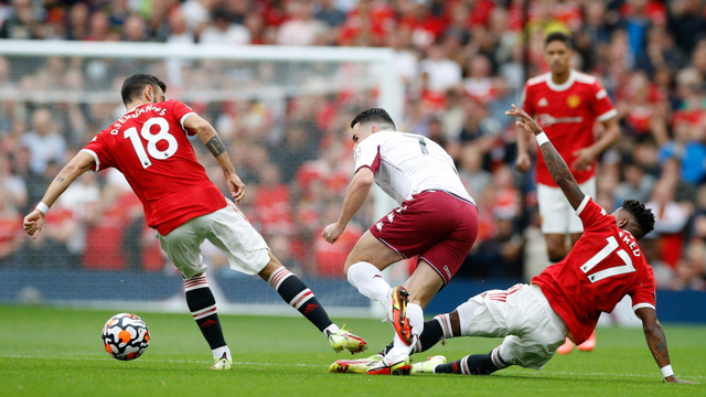 Bruno Fernandes dan Fred dari Manchester United beraksi dengan John McGinn dari Aston Villa pada pertandingan Liga Premier antara Manchester United melawan Aston Villa di Old Trafford, Manchester, Inggris, 25 September 2021. Foto: Phil Noble/Reuters