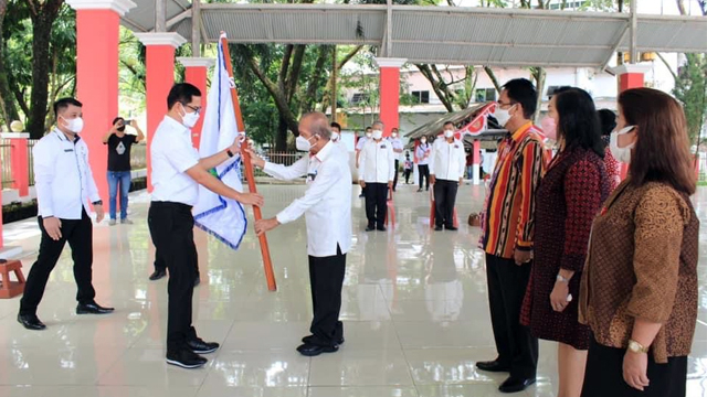 Bupati Minut, Joune Ganda, menyerahkan pattaka kepada Ketua Kerukunan Keluarga Pensiunan Pamong Praja (KKPP) Kabupaten Minahasa Utara, Martino Dengah