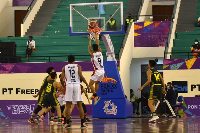 Aksi pemain Tim Basket Sulawesi Utara, Fernando 'Pikolo' Manansang, saat mencetak point di laga melawan tim Jawa Timur pada pertandingan penyisihan Grup B PON XX Papua. (foto: Ronny Adolof Buol)