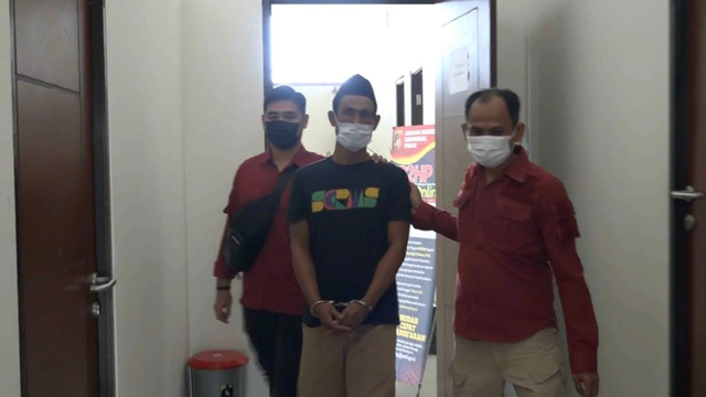 WARGA Kampung Terendam, Rumbai Pesisir, Pekanbaru, AS alias IB, dengan tangan terborgol dibawa anggota Ditnarkoba Polda Riau, Kamis (30/9/2021). 
