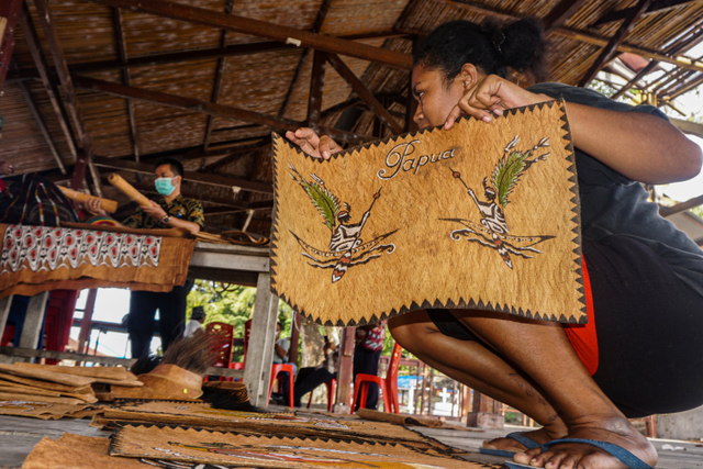 Seorang mama menata lukisan kulit kayu di Kampung Asey Pulau, Sentani Timur, Kabupaten Jayapura, Papua, Kamis (30/9).  Foto: Indrayadi TH/ANTARA FOTO
