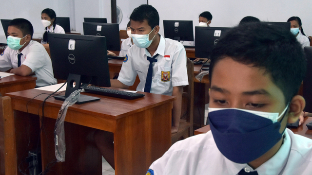 Siswa kelas VIII mengerjakan soal saat mengikuti Asesmen Nasional Berbasis Komputer (ANBK) 2021 di SMP Negeri 10 Denpasar, Bali. Foto: ANTARA FOTO/Nyoman Hendra Wibowo