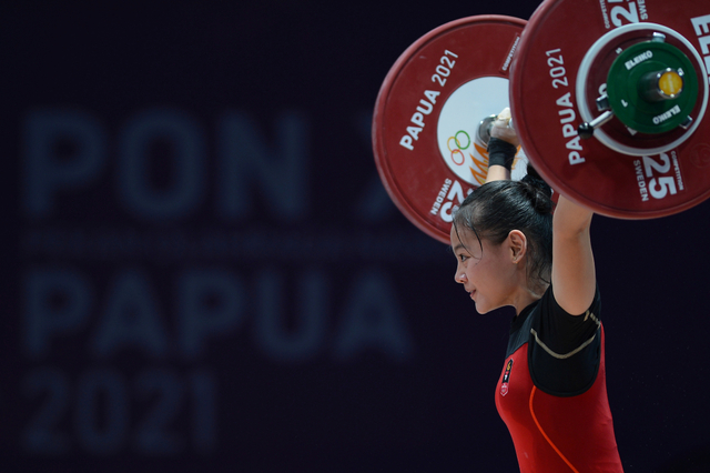 Lifter putri Jawa Barat Windy Cantika mengangkat beban pada kelas 49 kg PON Papua di Auditorium Universitas Cenderawasih, Kota Jayapura, Papua, Rabu (6/10/2021). Foto: Fauzan/Antara Foto