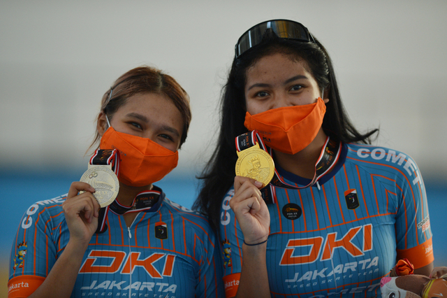 Atlet sepatu roda putri DKI Jakarta Alifia Meidia Namasta (kanan) dan Yemimma Lovellya (kiri) menunjukkan medalinya pada upacara pengalungan medali usai Elimination 10.000 meter putri PON Papua di Arena Klemen Tinal Roller Sport. Foto: ANTARA FOTO/Fauzan