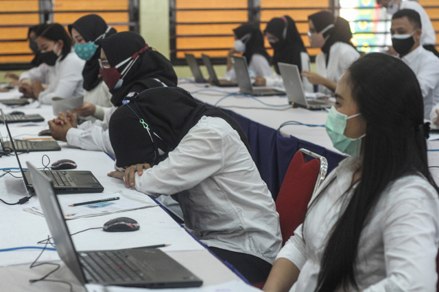 Peserta menunggu dimulainya tes Calon Aparatur Sipil Negara (CASN) di Balai Rakyat, Depok, Jawa Barat, Minggu (3/10). Foto: Asprilla Dwi Adha/ANTARA FOTO