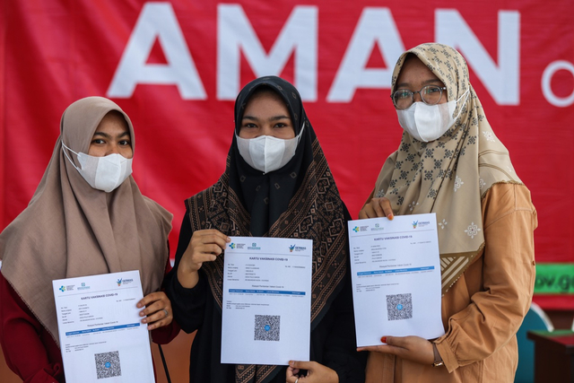 Warga menunjukkan sertifikat telah divaksin corona. Foto: Abdul Hadi/acehkini
