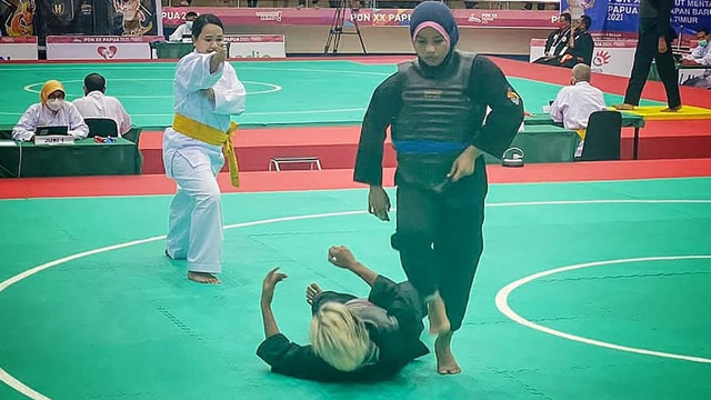 Atlet Pencak Silat Sumatera Barat Winda Nova Yelni menjatuhkan pesilat asal Jawa Timur, Surya Ningtyas di Gor Toware Kabupaten Jayapura, Selasa 12 Oktober 2021. Foto: dok KONI Sumatera Barat