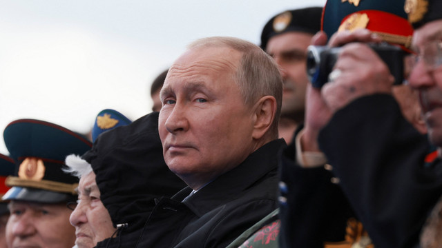 Presiden Rusia Vladimir Putin berjabat menyaksikan parade militer Hari Kemenangan ke-77 di Lapangan Merah, Moskow, Rusia, Senin (9/5/2022). Foto: Sputnik/Mikhail Metzel/Pool via REUTERS