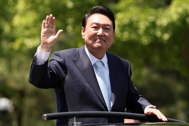 Presiden baru Korea Selatan Yoon Suk-yeol melambai kepada para pendukungnya saat pergi setelah menghadiri upacara pelantikannya di Majelis Nasional di Seoul, Korea Selatan, Selasa (10/5/2022). Foto: Yonhap via REUTERS