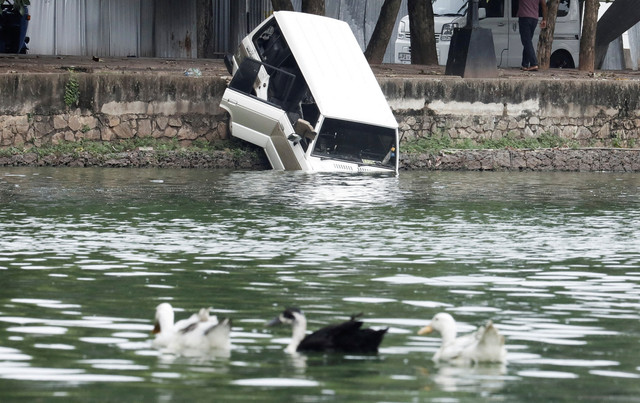 Kendaraan yang rusak akibat bentrokan demonstran pro dan anti-pemerintah di dekat kediaman resmi Perdana Menteri, didorong ke danau, di Kolombo, Sri Lanka, Selasa (10/5/2022). Foto: Dinuka Liyanawatte/REUTERS