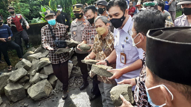 Sejumlah pejabat dan warga menyingkirkan batu yang menutupi akses ke TPST Piyungan, Kamis (12/5/2022). Foto: Erfanto/Tugu Jogja