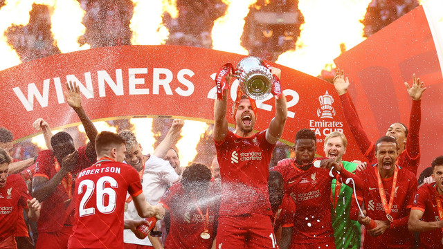 Pemain Liverpool Jordan Henderson mengangkat trofi saat mereka merayakan setelah memenangkan Piala FA, di Stadion Wembley, London, Inggris, Sabtu (14/5/2022). Foto: Hannah McKay/REUTERS