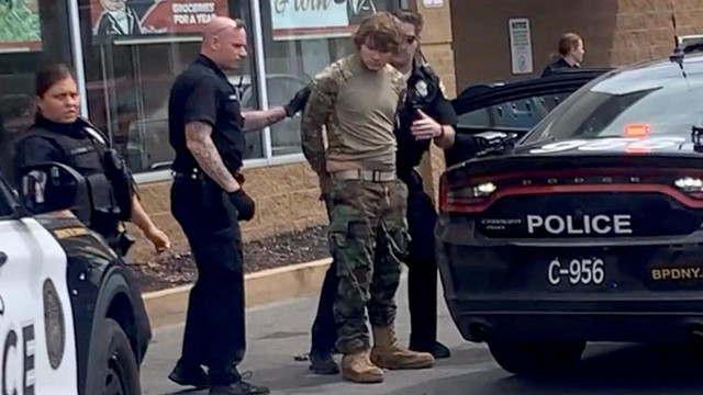 Seorang pria ditahan setelah penembakan massal di tempat parkir supermarket TOPS, dalam gambar diam dari video media sosial di Buffalo, New York, AS, Sabtu (14/5/2022). Foto: Courtesy of BigDawg/via REUTERS
