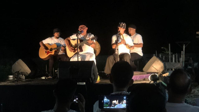 Rafli Kande saat tampil menghibur warga lewat syair-syairnya dalam kegiatan bertajuk 'Puleh' di sebuah kafe di Aceh Barat, Sabtu (14/5/2022) malam. Foto: Siti Aisyah/acehkini