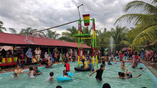 Sejumlah pengunjung tengah menikmati wahana pemandian Ajo Manenggang di Dharmaraya, Sumatera Barat. Foto: dok Pemkab