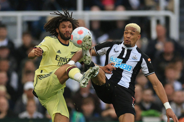 Pemain Arsenal Mohamed Elneny berebut bola dengan pemain Newcastle United Joelinton pada pertandingan lanjutan Liga Inggris di Stadion St James' Park, Newcastle, Inggris. Foto: Lee Smith/REUTERS