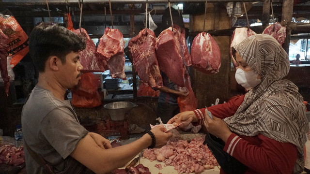 Pedagang daging sapi bertransaksi dengan pembeli di Pasar Minggu, Jakarta, Selasa (17/5/2022). Foto: Jamal Ramadhan/kumparan