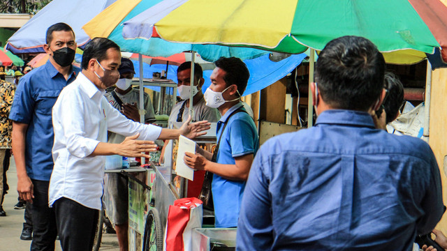 Presiden Joko Widodo memberikan bantuan modal usaha UMKM kepada pedagang saat mengunjungi Pasar Cibinong di Kabupaten Bogor, Jawa Barat, Selasa (17/5/2022). Foto: Yulius Satria Wijaya/ANTARA FOTO
