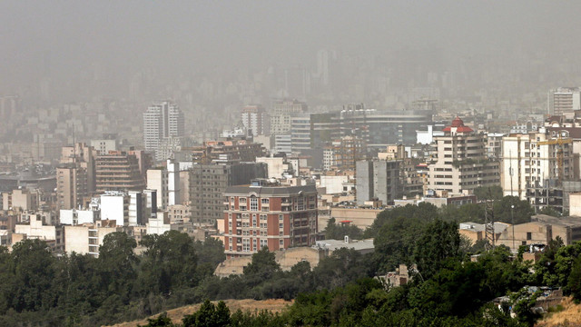 Badai pasir melanda gedung-gedung di utara ibu kota Iran, Teheran, Iran, Selasa (17/5/2022). Foto: AFP