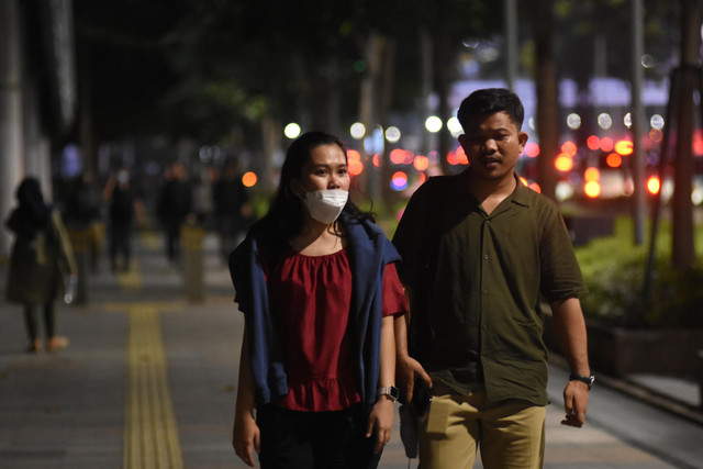 Pekerja berjalan di trotoar kawasan Jalan Jenderal Sudirman, Jakarta, Selasa (17/5/2022).  Foto: Indrianto Eko Suwarso/ANTARA FOTO