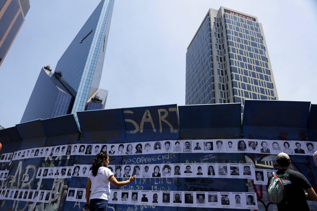 Kerabat orang hilang menempatkan foto orang yang mereka cintai saat mereka menuntut pembangunan tugu peringatan yang didedikasikan untuk semua orang yang hilang di negara itu, di Mexico City, Meksiko, Minggu (15/5/2022). Foto: Luis Cortes/REUTERS