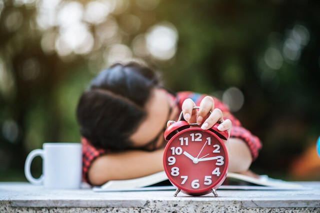 young girl lying down desk after reading book (image source: freepik.com).
