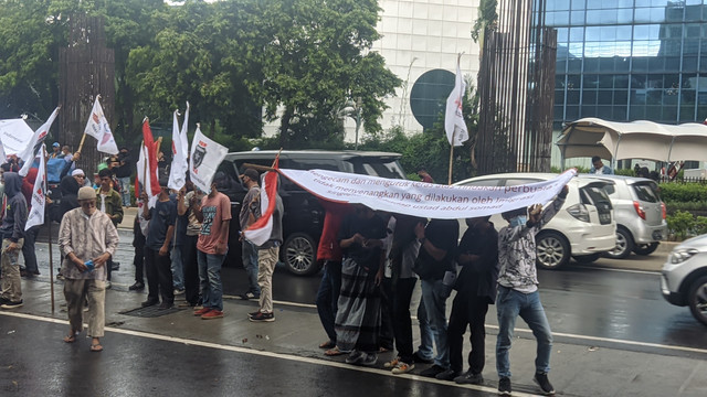 Aksi unjuk rasa di depan Kedubes Singapura diterpa hujan, Jumat (20/5/2022). Foto: Jonathan Devin/kumparan