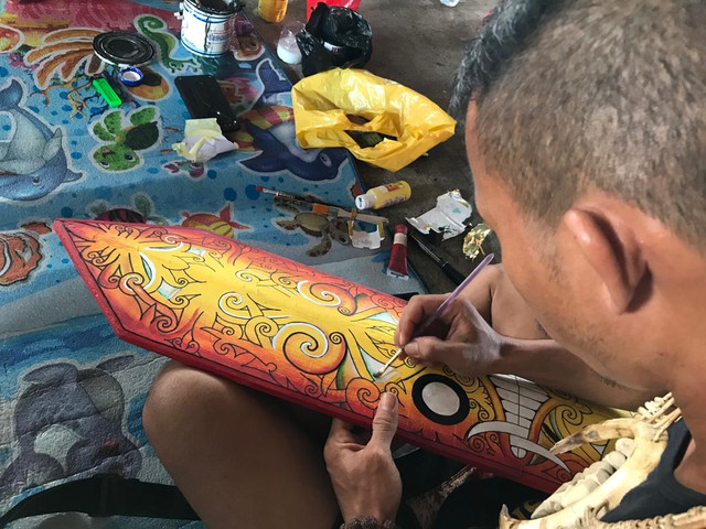 Salsah satu pria melukis perisai di Pekan Gawai Dayak ke-36. Foto : Lydia Salsabila/ Hi!Pontianak