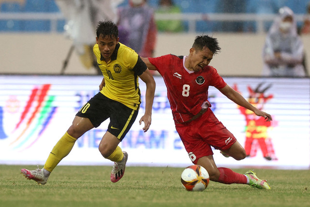Pemain Timnas Indonesia Witan Sulaeman berebut bola dengan pemain Timnas Malaysia pada pertandingan perebutan medali perungu SEA Games 2021 Vietnam di Stadion Viet Tri - Viet Tri, Vietnam. Foto: Chalinee Thirasupa/REUTERS