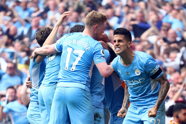 Pemain Manchester City Joao Cancelo melakukan selebrasi setelah Ilkay Gundogan mencetak gol ketiga mereka saat hadapi Aton Villa, di Stadion Etihad, Manchester, Inggris, Minggu (22/5/2022). Foto: Hannah McKay/REUTERS
