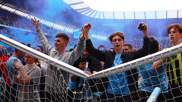 Penggemar merayakan di lapangan setelah Manchester City memenangkan Liga Premier di Stadion Etihad, Manchester, Inggris, Minggu (22/5/2022). Foto: Hannah McKay/REUTERS