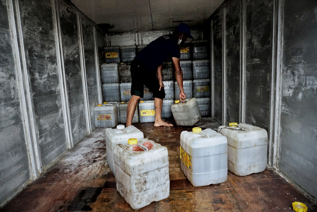 Pekerja mengangkat minyak goreng curah kemasan jirigen di Kawasan Kebayoran Lama, Jakarta Selatan, Senin (23/5/2022). Foto: Jamal Ramadhan/kumparan