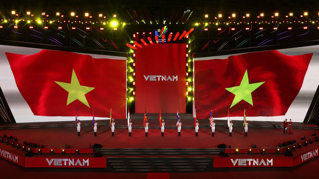 Petugas membawa bendera Vietnam saat acara penutupan SEA Games 2021 Vietnam di Vietnam Asian Indoor Games Stadium, Hanoi, Vietnam, Senin (23/5/2022). Foto: Chalinee Thirasupa/REUTERS
