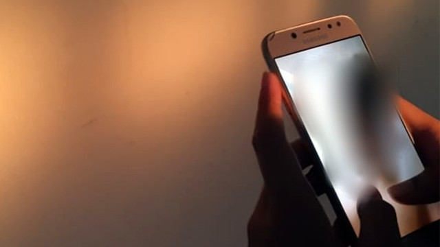 Ilustrasi menonton video asusila di handphone. (foto: dokumen kumparan)