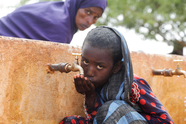 Seorang pengungsi minum air dari keran di kamp pengungsian Kaxareey di Dollow, Gedo, Somalia, Selasa (24/5/2022).Seorang pengungsi minum air dari keran di kamp pengungsian Kaxareey di Dollow, Gedo, Somalia, Selasa (24/5/2022). Foto: Feisal Omar/REUTERS