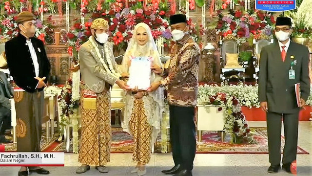 Adik Presiden Jokowi, Idayati, dan Ketua MK Anwar Usman menerima KTP dan KK dari Dirjen Dukcapil Kemendagri Zudan Arif Fachrullah di Graha Saba Buana, Solo, Kamis(26/05/2022). FOTO: Tangkap layar streaming Pengantin Production