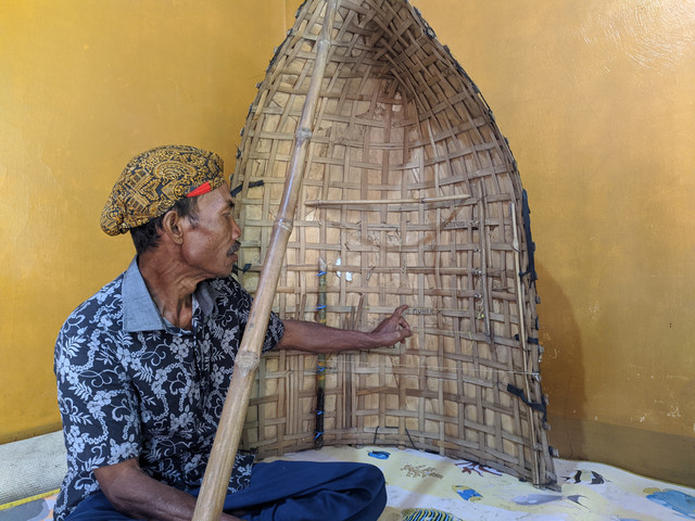 Munir, adik kandung Barnawi sedang memperkenalkan alat musik Bundengan.