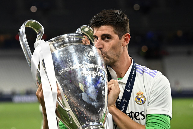 Kiper Real Madrid Thibaut Courtois merayakan kemenangan Liga Champions dengan trofi di Stade de France, Saint-Denis dekat Paris, Prancis, Sabtu (28/5/2022). Foto: Dylan Martinez/REUTERS