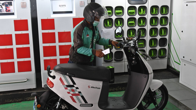 Pengemudi ojek daring mengganti baterai sepeda motor listriknya di stasiun pengisian baterai listrik di Kuningan, Jakarta, Senin (30/5/2022). Foto: Aditya Pradana Putra/ANTARA FOTO
