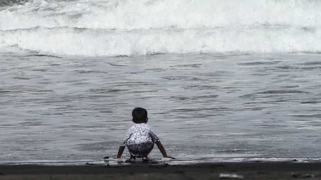 Seorang anak kecil bermain air di Pantai Cemoro Sewu, Parangtritis, Bantul, DI Yogyakarta, Selasa (31/5/2022). Foto: Hendra Nurdiyansyah/ANTARA FOTO