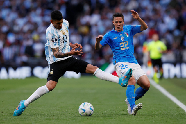 Pemain Timnas Argentina Cristian Romero berebut bola dengan pemain Timnas Italia Giacomo Raspadori pada pertandingan Finalissima 2022 di Stadion Wembley, London, Inggris. Foto: Andrew Couldridge/REUTERS
