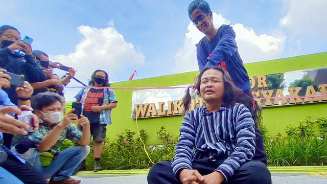 Di depan Balai Kota Yogya pada Sabtu (4/6), Dodok Putra Bangsa dicukur oleh Elanto Wijoyono, Humas Festival Seni Mencari Haryadi. Foto: Widi Erha Pradana