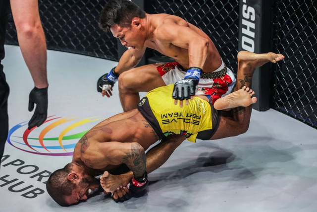 Alex Silva meraih kaki Adrian Mattheis untuk mengeksekusi teknik heel hook dalam laga MMA di ONE 158 pada Jumat (3/6/2022). Foto: ONE Championship 
