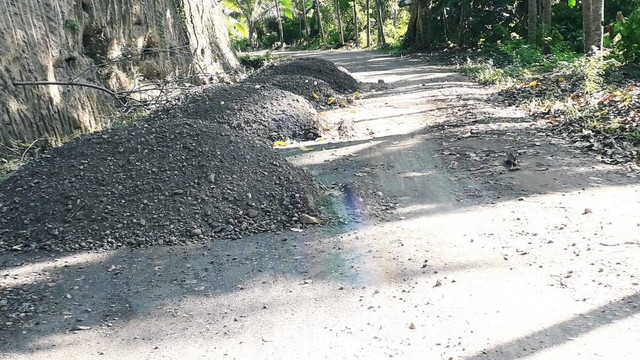 Keterangan foto: Tumpukan material sepanjang jalan di tengah pemukiman warga di Desa Bola, Minggu (5/6). Foto oleh: Athy Meaq.