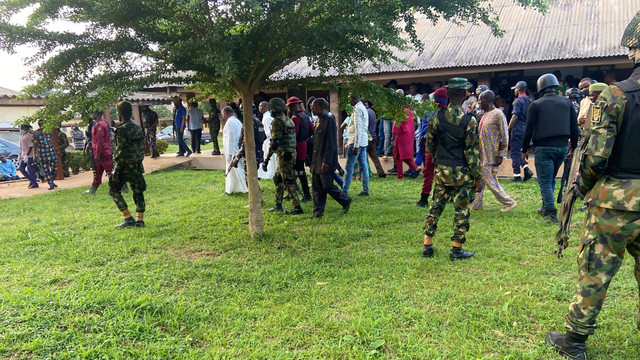 Petugas keamanan menjaga Gubernur Negara Bagian Ondo Rotimi Akeredolu saat mengunjungi para korban serangan bom di gereja Katolik St. Francis, di Owo, Nigeria, 5 Juni 2022. Foto: REUTERS/Stringer