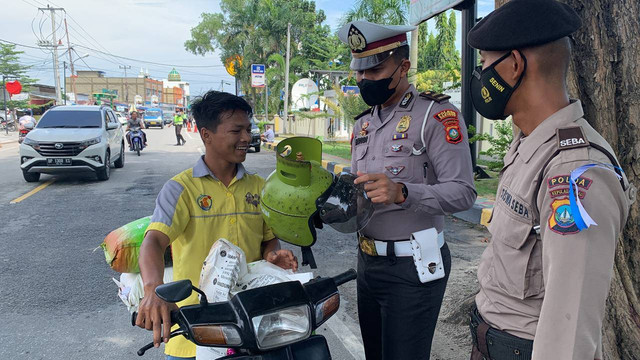 Pemotor dengan helm mirip tabung gas diberhentikan polisi saat razia lalu-lintas di Karimun. (Foto: Edo/Batamnews)