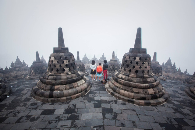 Pengunjung menyaksikan matahari terbit di Candi Borobudur, Magelang, Jawa Tengah.  Foto: Oscar Siagian/Getty Images.