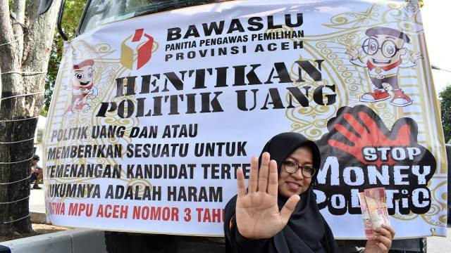Seorang pengawas Pemilu 2019 memperagakan stop money politic saat apel siaga pengawasan di Banda Aceh, Jumat (12/4/2019). Foto: Adi Warsidi/acehkini